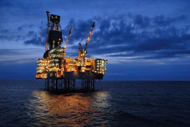 Offshore oil platform illuminated at dusk